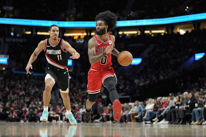 Chicago Bulls point guard Coby White (0) dribbles the ball while defended by Portland Trail Blazers point guard Malcolm Brogdon (11) during the first half at Moda Center.